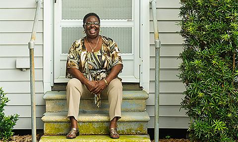 Woman laughing in front of home